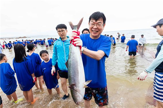 ‘Sh수협은행 제18회 사랑海 썸머페스티벌’에 참가한 고객 가족이 ‘맨손 물고기잡기’ 를 체험하며 즐거워하는 모습.