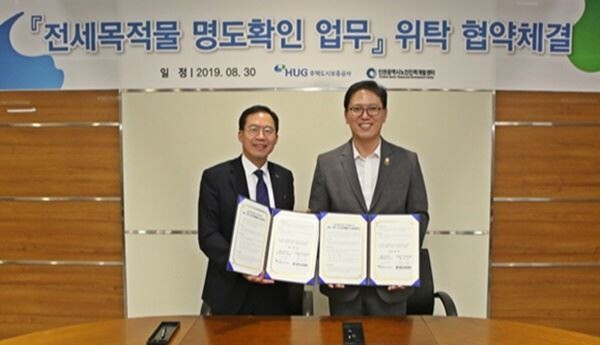 오원택 HUG 자산관리본부장(왼쪽), 정웅 인천 노인인력개발센터 회장(오른쪽)이 '전세목적물 명도확인 업무' 위탁 협약을 체결한 후 기념촬영을 하고 있다.