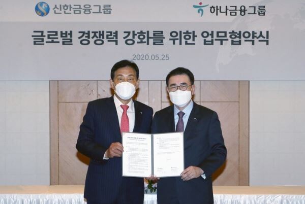 25일 서울 중구에 소재한 롯데호텔에서 조용병 신한금융지주 회장(오른쪽)과 김정태 하나금융지주 회장(왼쪽)이 글로벌 경쟁력 강화를 위한 MOU를 체결하고 글로벌 사업에 있어 업무제휴를 추진하기로 하고 기념촬영을 하고 있다.[사진제공=신한금융지주]