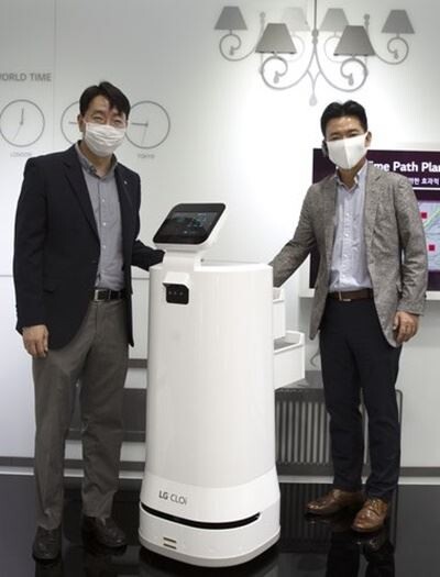 GS25가 LG전자와 손잡고 인공지능(AI) 자율주행 로봇을 이용한 배송 서비스를 도입한다. 김성기 GS리테일 상무(사진 오른쪽)와 정원진 LG전자 상무가 배달 로봇과 함께 포즈를 취하고 있다./ (사진=GS리테일)