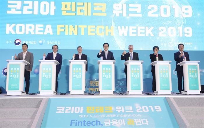 5월 23일 동대문디자인플라자(DDP)에서 열린 ‘코리아 핀테크 위크 2019(Korea Fintech Week 2019)’개막식 참석자들이 기념사진을 찍고 있다. (왼쪽부터) 김대윤 한국핀테크산업협회장, 매트 딜 비자 글로벌 대표, 더글라스 페이건 안트 파이낸셜 대표, 최종구 금융위원장, 사이먼 스미스 주한영국대사, 정유신 한국핀테크지원센터장, 김태영 전국은행연합회장[사진=금융위원회]