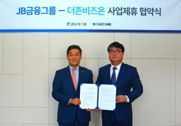 JB금융그룹 김기홍 회장(왼쪽)과 더존비즈온 김용우 대표가 지난 18일 서울 여의도 JB빌딩에서 MOU를 체결했다.[사진제공=JB금융]