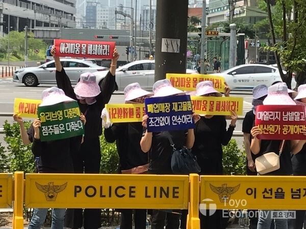 ▲전국아리따움가맹점주협의회가 22일 서울 용산에 위치한 아모레퍼시픽 본사앞에서 집회를 열었다. 집회에 참석한 가맹점주들이 피켓을 들고 있는 모습. [사진=김자혜 기자]